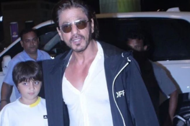 As they walk to the airport, Shah Rukh Khan holds his son AbRam's hand.